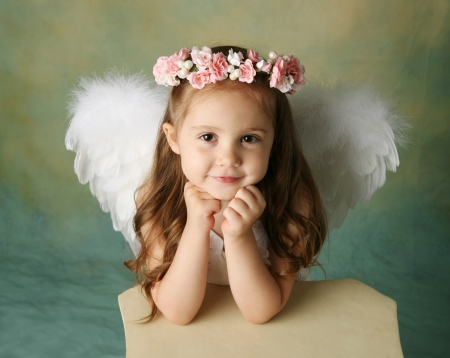 Beautiful young girl wearing angel wings and flower halo with smile happy expressionの写真素材