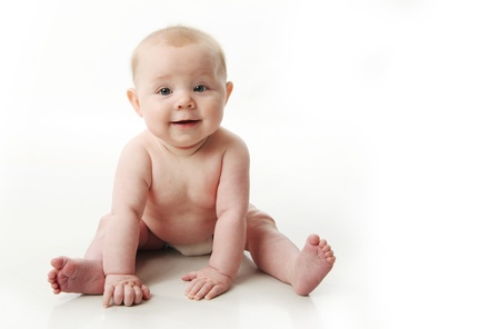 Portrait of an adorable baby sitting up wearing a diaper and smiling, isolated on whiteの写真素材
