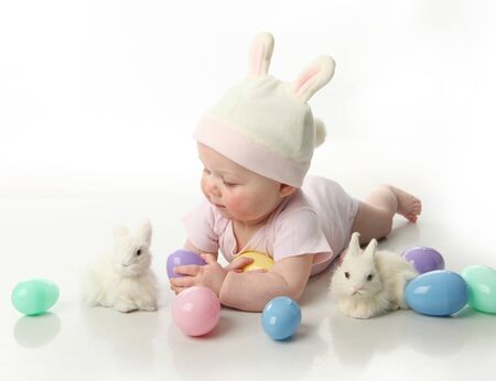 Portrait of a cute baby dressed in Easter bunny ears with eggs