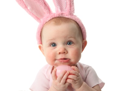 Portrait of a cute baby dressed in Easter bunny ears pastel eggsの写真素材