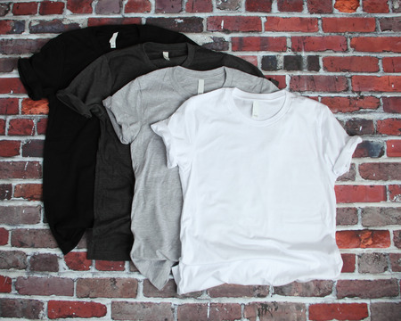Flat lay mockup of gray, white and black tee shirts on brick backgroundの写真素材