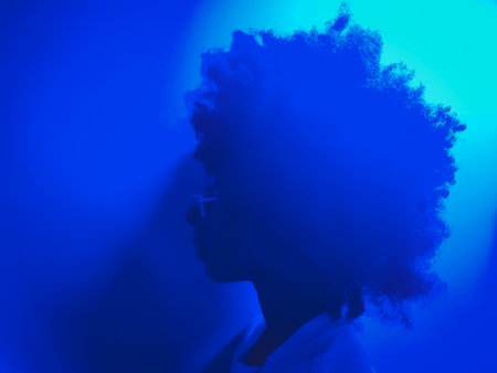 neon blue girl with afro hairstyle straight face looking forward to the leftの写真素材