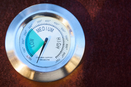 temperature gage on outside of BBQ grill. close up low medium high scale rustの写真素材