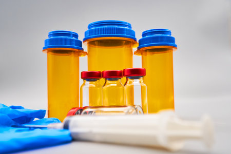 Medical vials and syringes with blue caps on white background