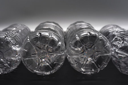 Empty plastic water bottles recycle material reduce waste grey and black backgroundの写真素材