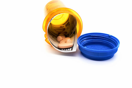 Paying a lot of money for medication and prescription pills hundred dollar bill medicine bottle child proof white backgroundの写真素材