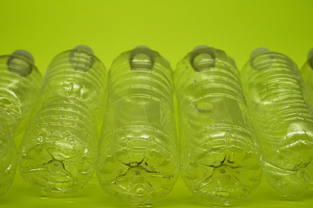 Empty plastic water bottles recycle material reduce waste neon green backgroundの写真素材