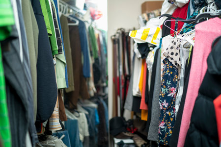 messing closet clothing jeans shirts belts purses attire multiple colorsの写真素材