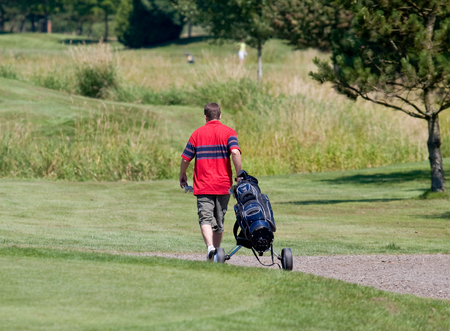 golfer walking down the fairwayの写真素材