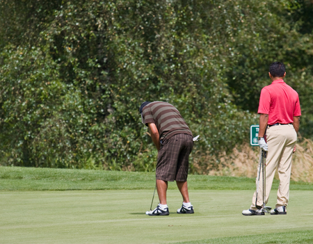 golfer putting while golfer watchesの写真素材