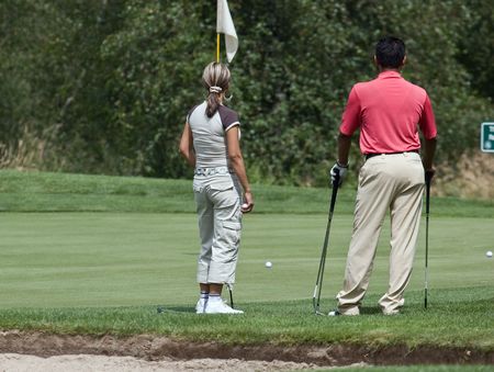 two golfers waiting to puttの写真素材