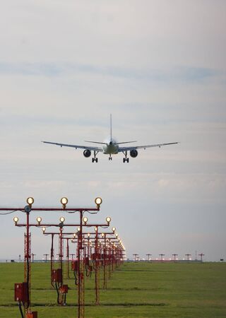jet coming into land over runway lightsの写真素材