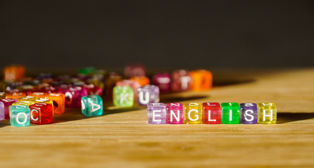 Word English from a square of colored blocks on a wooden surface.
