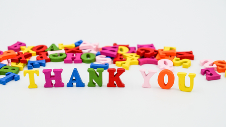 The phrase "Thank you" built of wooden colored letters. Scattered in the background, colorful letters.の写真素材