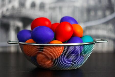 Multicolored eggs for Easter in a steel basket.の写真素材
