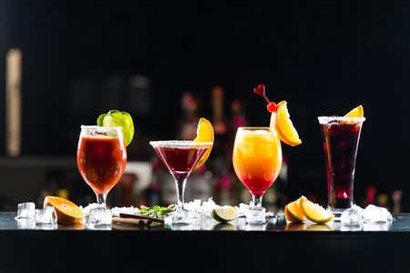 Multi-colored alcoholic cocktails with citrus in glasses of different shapes on the bar.の写真素材