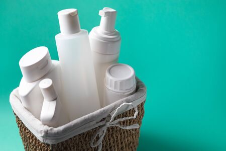 A basket full of white plastic cosmetic bottles on a blue background with copy spaceの写真素材