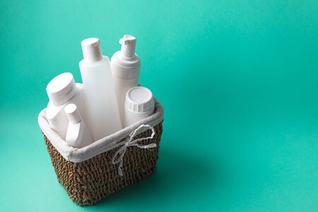 A basket full of white plastic cosmetic bottles on a blue background with copy spaceの写真素材