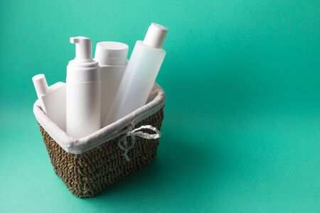 A basket full of white plastic cosmetic bottles on a blue background with copy spaceの写真素材