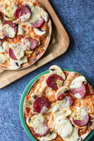 Two pepperoni pizza with mozzarella cheese, white mushroom and srirachaの写真素材