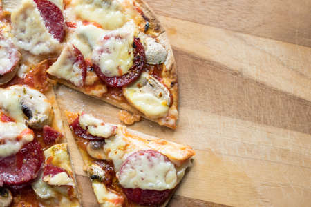 Sliced salami pizza with mozzarella cheese, white mushroom and srirachaの写真素材