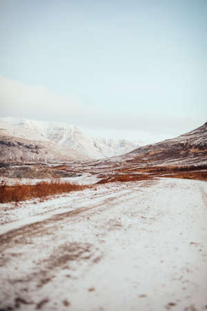 An icy road near mountains in Iceland during wintertimeの写真素材