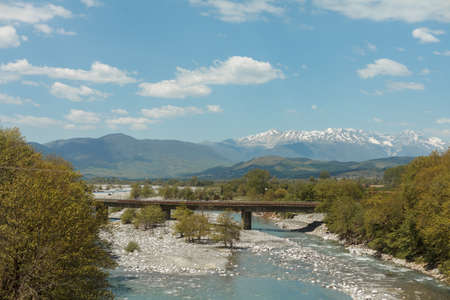 Bridge over Vjosa river near Konitsa river in northwestern Greece with mountains on the backgroundの写真素材