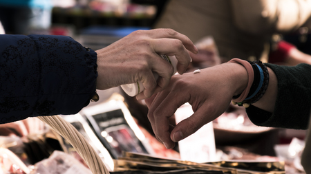 Trying a hand cream in a street store in old Madrid. In the area of Madrid de los Austriasの写真素材
