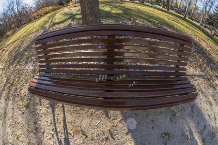 Fisheye 180 view of a wooden bench in the Retiro Park in Madrid city, Spain
