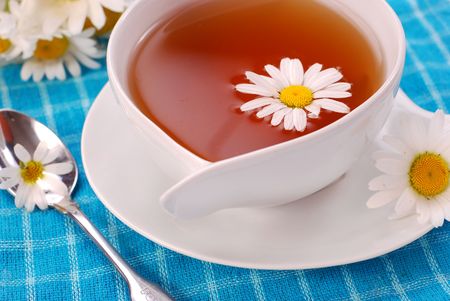 camomile tea in white cup on blue backgroundの写真素材