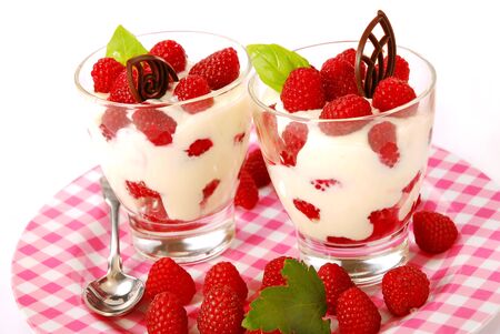 two glasses of raspberry dessert with vanilla creamの写真素材