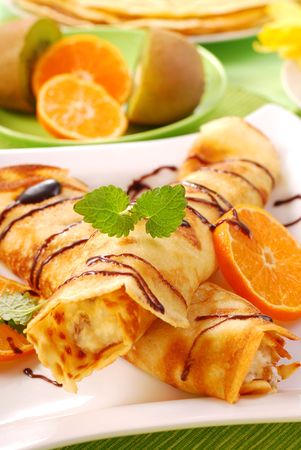 rolled pancakes with cottage cheese and orange poured chocolateの写真素材