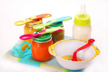 jars of various baby food and bottle of milkの写真素材