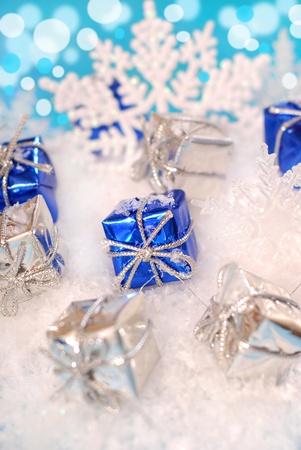 small christmas gift boxes lying  on snow  with shining effect in backgroundの写真素材