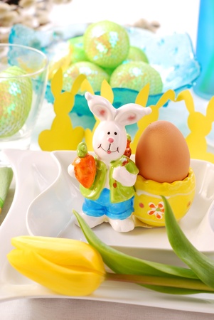 easter table decoration with rabbit`s figurine and egg on plate