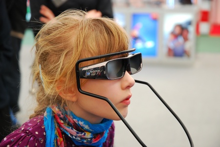 LODZ-16,04,2011 FOTO-VIDEO FAIR. Girl trying SONY 3D glasses for new technology television and games.のeditorial素材