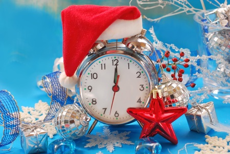 retro alarm clock in santa claus hat with  christmas decoration 