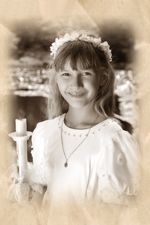 vintage portrait of a girl in white dress and wreath ,going to the first holy communion and posing...