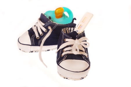 baby boy`s shoes with pregnancy test and dummy isolated on whiteの写真素材