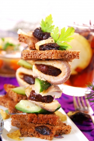 herring canapes with dark bread in star shape,prune and gherkin on christmas eve`s tableの写真素材