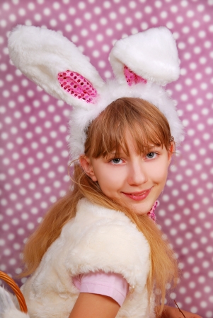 easter bunny girl with funny ears on purple background with dots の写真素材