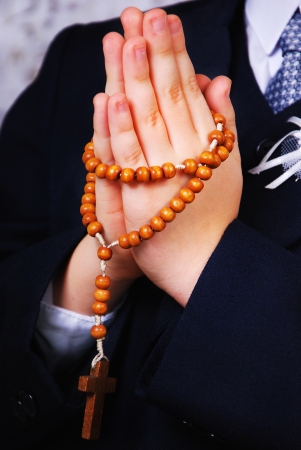 Hands of the boy going to the First Holy Communion set in amen with a rosaryの写真素材
