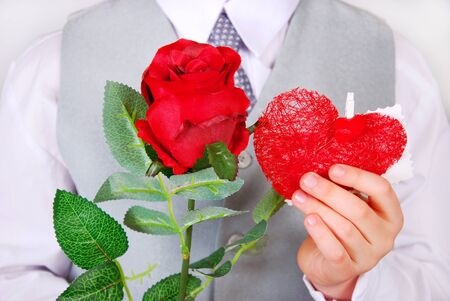 little boy giving red rose and heart with greetingsの写真素材