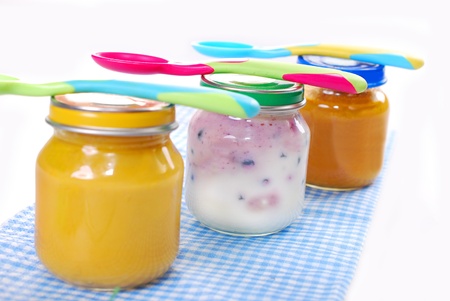 jars with baby food and spoons isolated on whiteの写真素材