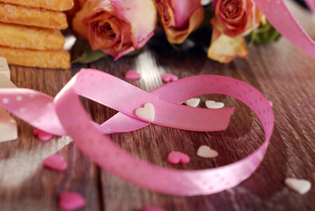 pink ribbon in heart shape on wooden table as love symbol の写真素材