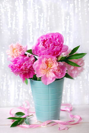 beautiful pink peony bouquet in vase on white shining の写真素材