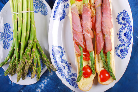 baked baguette with green asparagus wrapped in prosciutto hamの写真素材