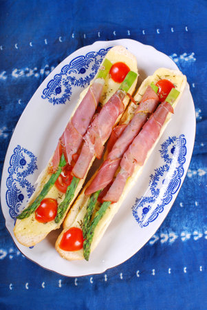 baked baguette with green asparagus wrapped in prosciutto ham の写真素材