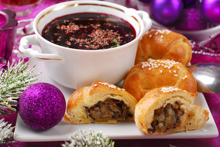 cup of traditional red borscht and yeast pastries with mushrooms filling for christmas eveの写真素材