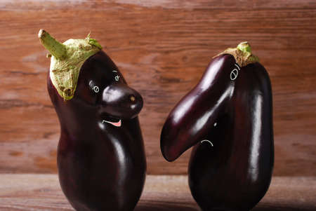 two funny and strange grown eggplants with eyes and mouth drawnの写真素材